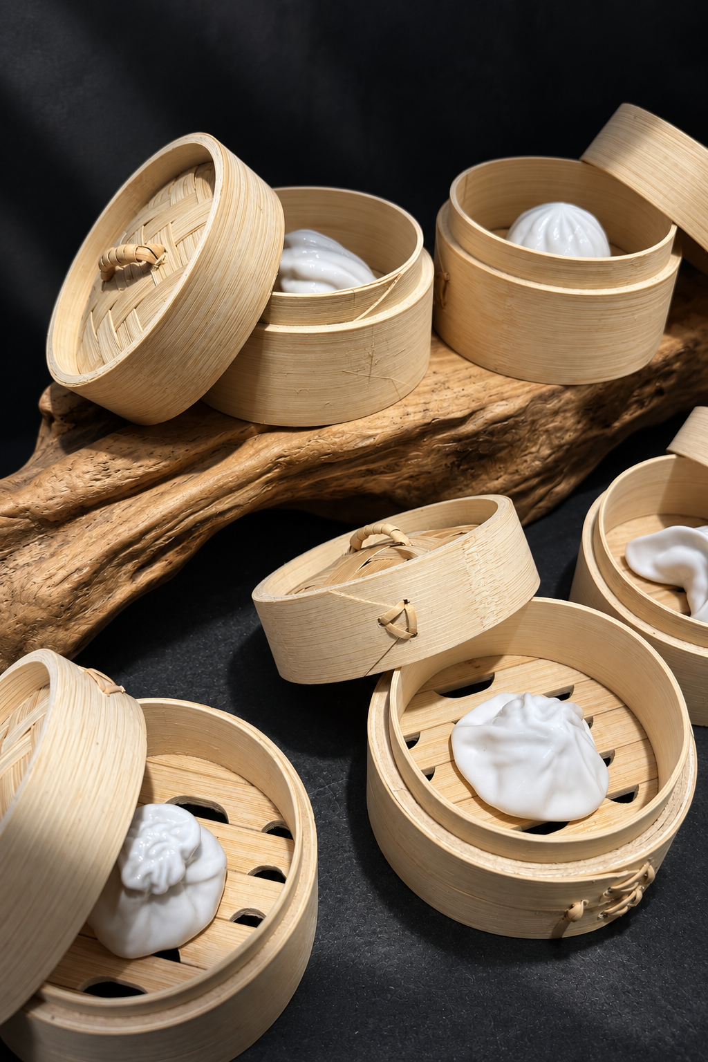 White ceramic forms presented in traditional bamboo steamers